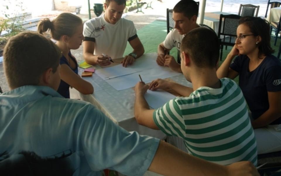 group of youth at sitting around a table 