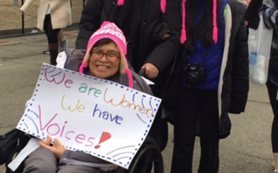 women a wheel holding a poster 