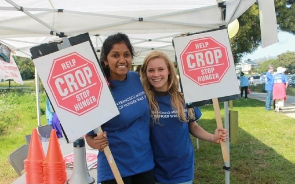 two young girls are holding signs 