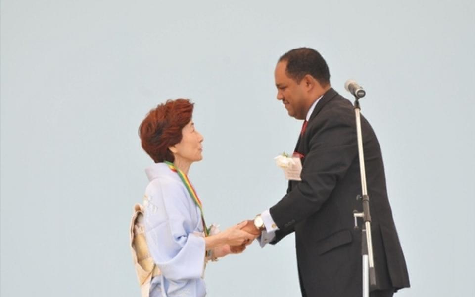 Mussie Hailu, shaking hand with a women in japan 
