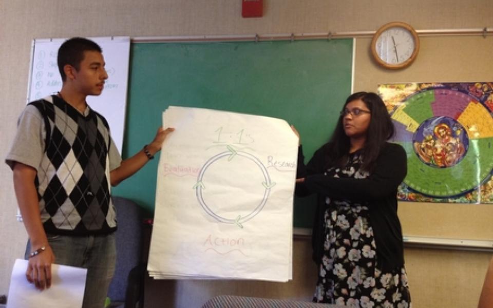 A girl and young man is holding a sign 