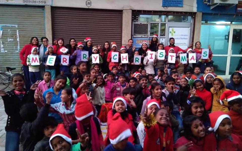 Children and adults in Christmas caps with banners in their hands.